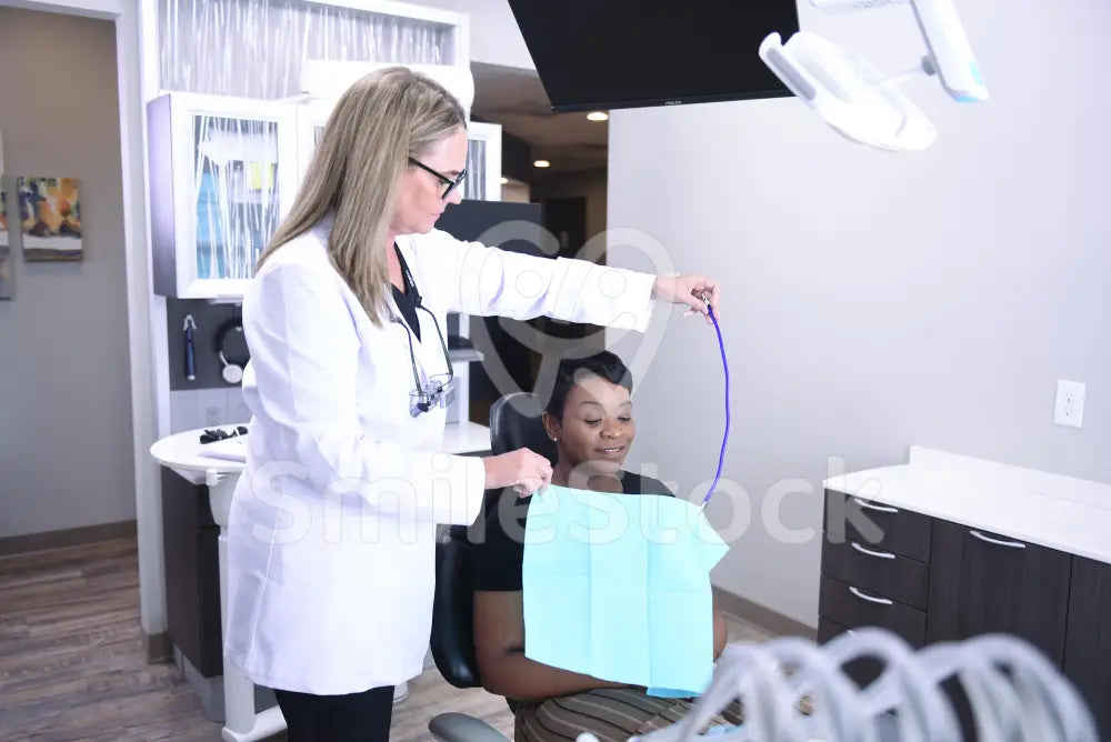 Hygienist Looking Closely at Patient’s Mouth During Exam - Treatment Room