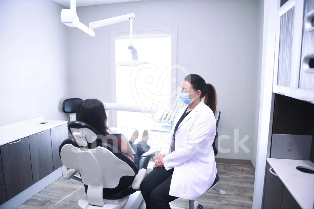 Hygienist Making Adjustments to Patient’s Chair - Treatment Room