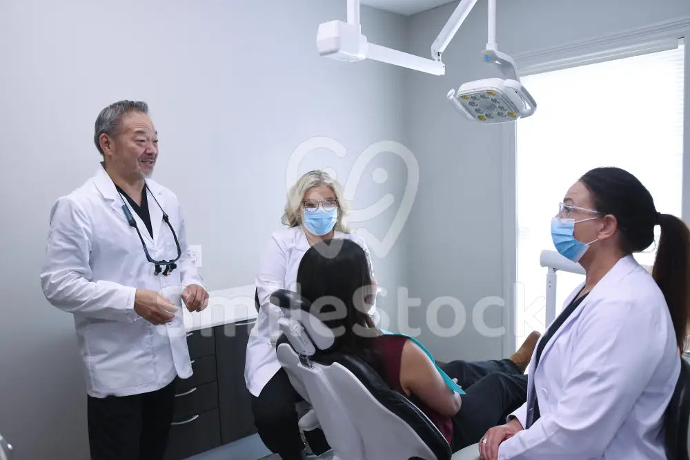 Three Clinicians Consulting on Patient’s Dental Health - Dental Team Images